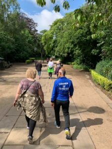 Group of people out walking in leafy green surroundings 