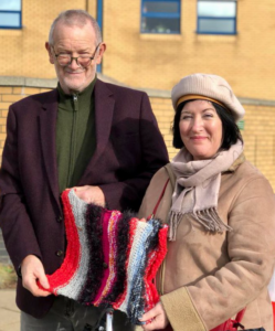 Terry and Dawn holding a knitted blanket