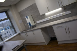 Refurbished kitchen with white cupboards and window