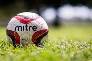 A colourful football on a grass pitch
