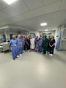 A patient pictured with staff in a hospital