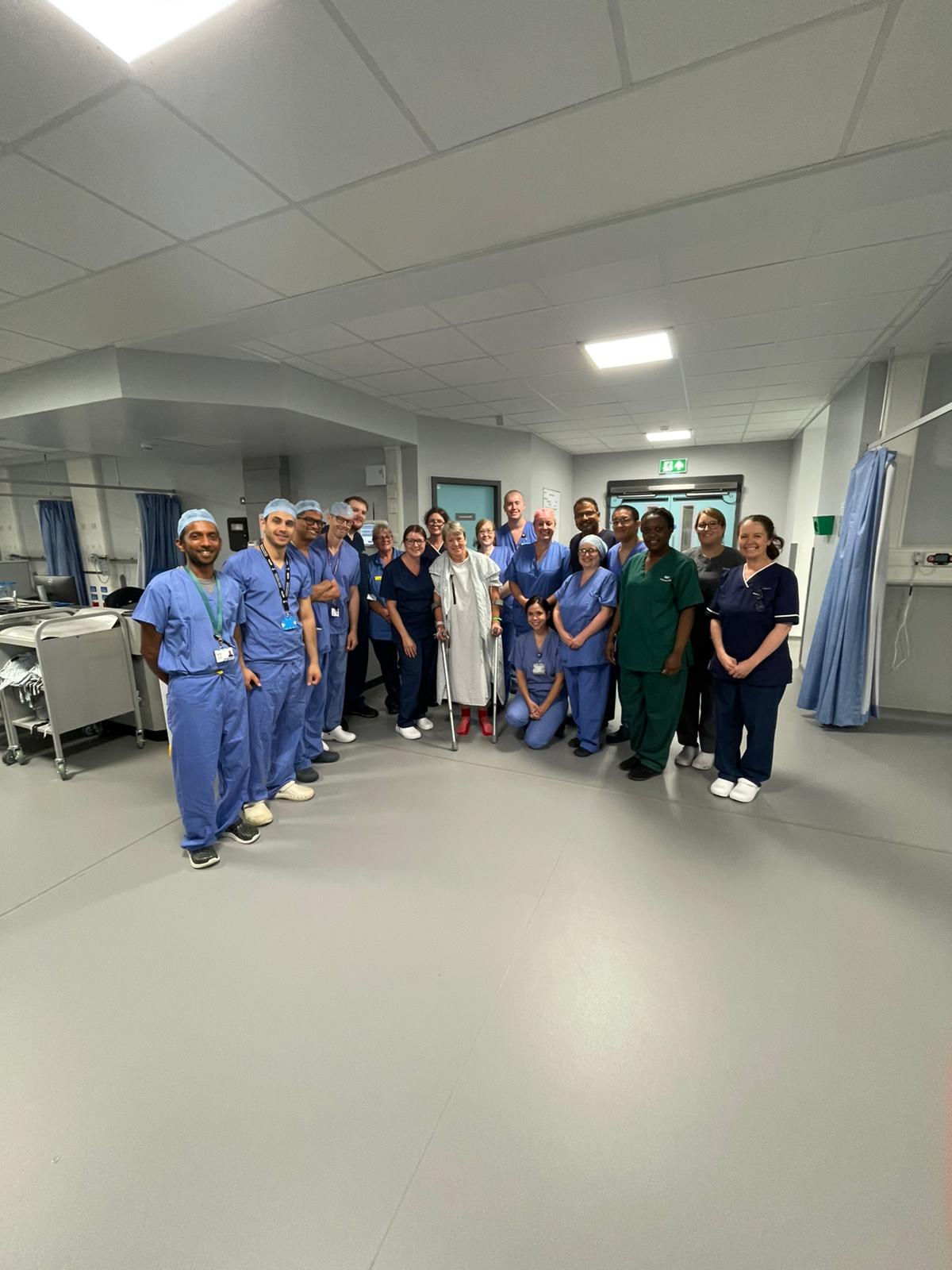 A patient pictured with staff in a hospital