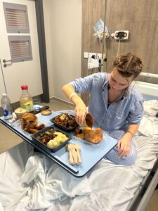 A young woman in hospital about to eat a tray of food