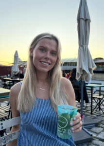 A young woman with a drink smiling