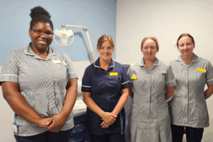 Four women in nursing uniforms standing in a line