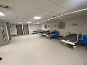 The interior of the new temporary discharge lounge. Three trollies are in a large, bright area