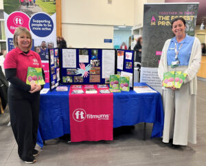 Two women stood in front of an information stand