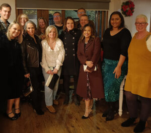 A group of people stood smiling in a room