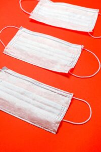 Surgical face masks lined up on an orange background