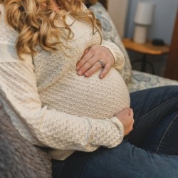 A generic image of a woman with long blonde curls holding her bump